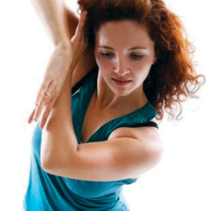 a woman looking down with her arms up to her head